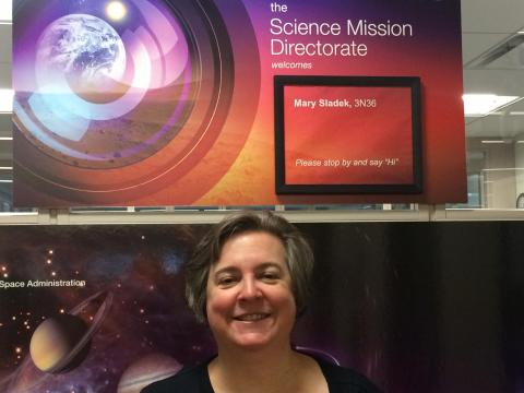 Mary F. Sladek in front of a poster board with her name and "Science Mission Directorate".